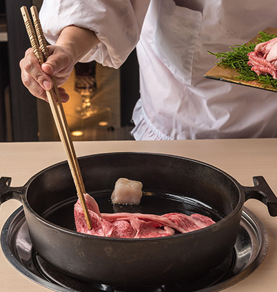 すき焼き鍋で肉を焼くシーン